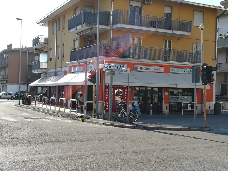 La facciata arancione con le tende bianche vista dall'incrocio